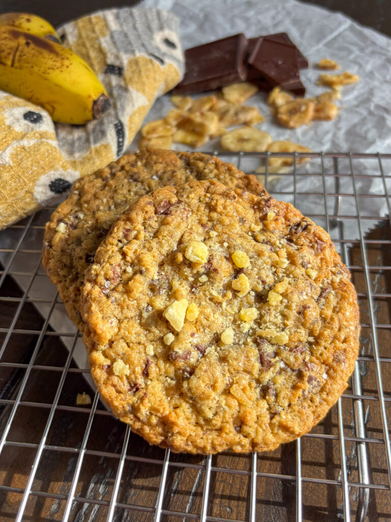 Soft banana oat cookies with chopped chocolate on a cooling rack