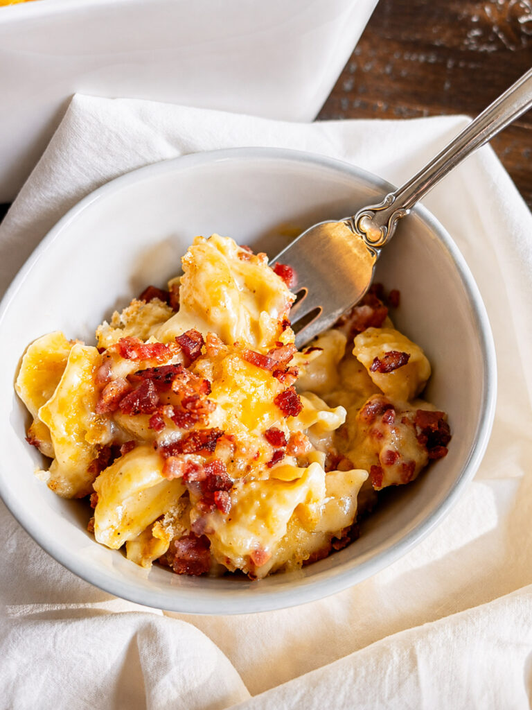 Creamy Gouda mac and cheese with crispy bacon and a golden breadcrumb topping served in a bowl.
