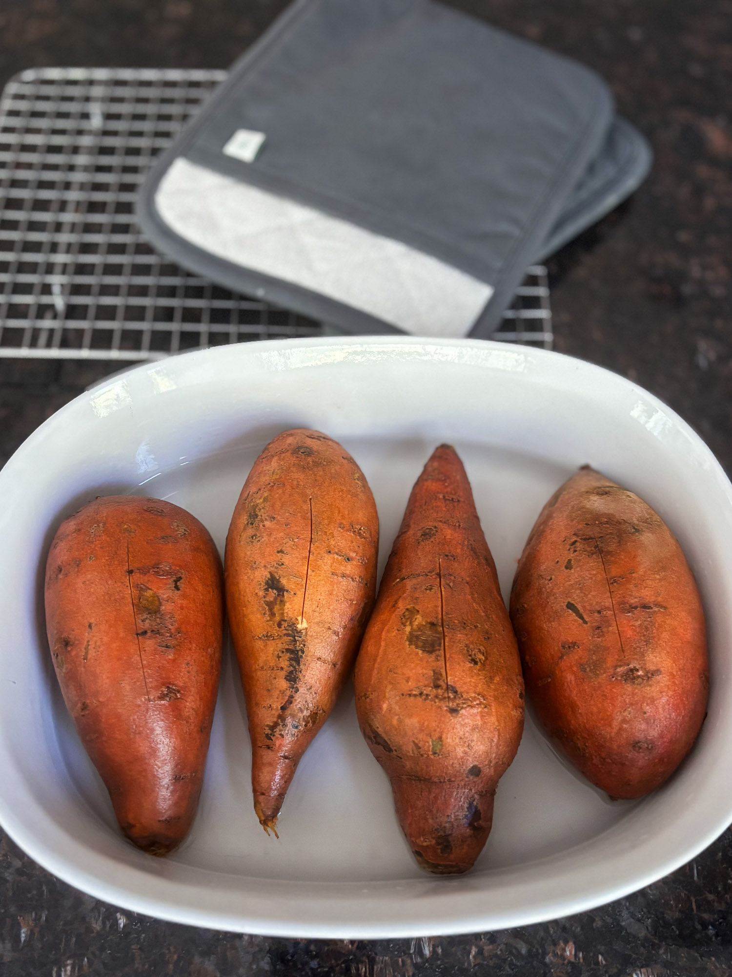 Baked Sweet Potatoes with Harvest Honey Butter-1 Four unpeeled sweet potatoes arranged in a white bowl