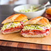 talian grinder sandwich piled with Italian meats, provolone, pepperoni, banana peppers, red onion, and creamy deli slaw on a sub roll.
