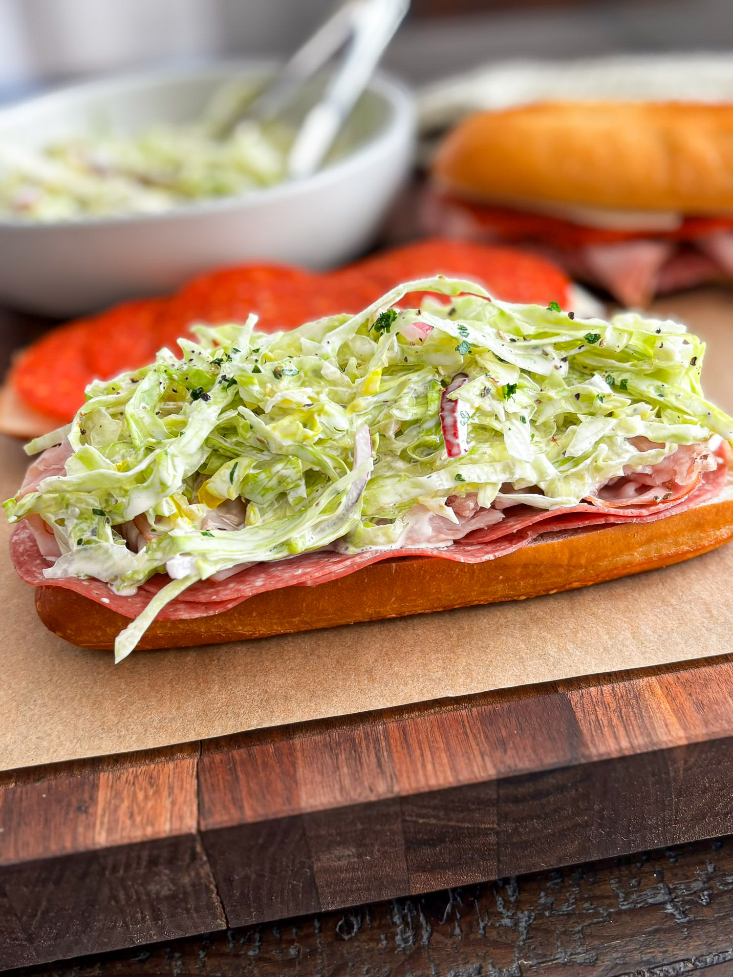 Italian Grinder Sandwich with Creamy Deli Slaw 2 Italian sub sandwich with cured meats, creamy shredded lettuce, tomato, and onion