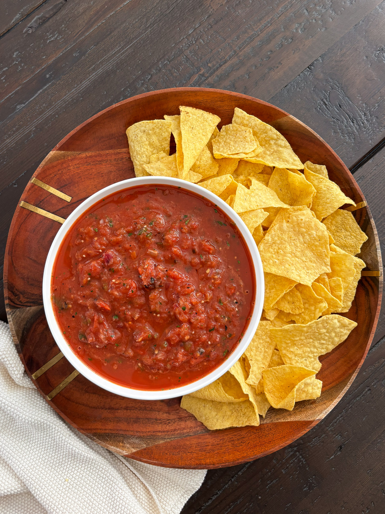 Roasted Tomato Salsa 2 Bowl of red salsa surrounded by yellow tortilla chips on a wooden platter