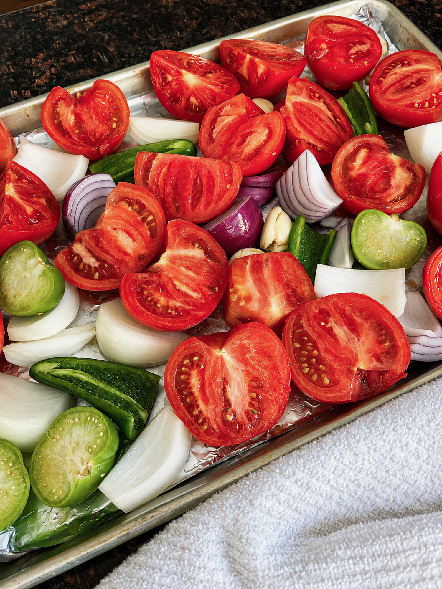 Roasted Tomato Salsa 2 Halved tomatoes, onions, jalapeños, and green tomatoes arranged in a foil-lined tray